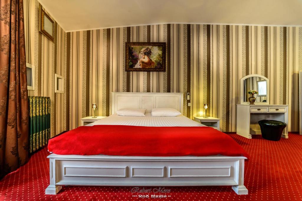 a bedroom with a large bed with a red blanket at Vila Sia in Bucharest