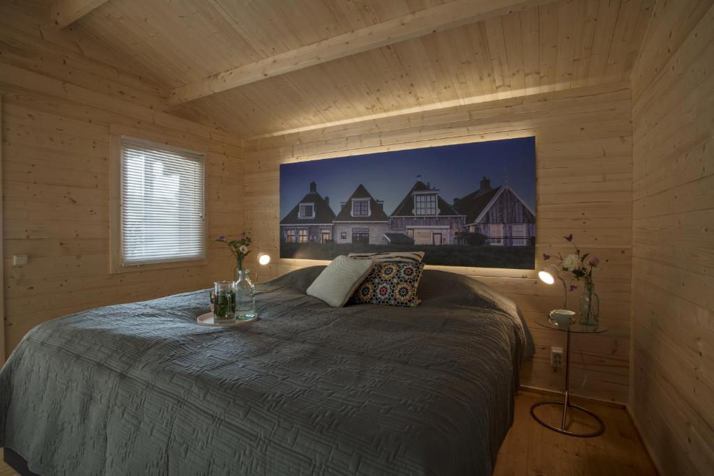 een slaapkamer met een bed in een houten hut bij Lodgehotel de Lelie in Makkum