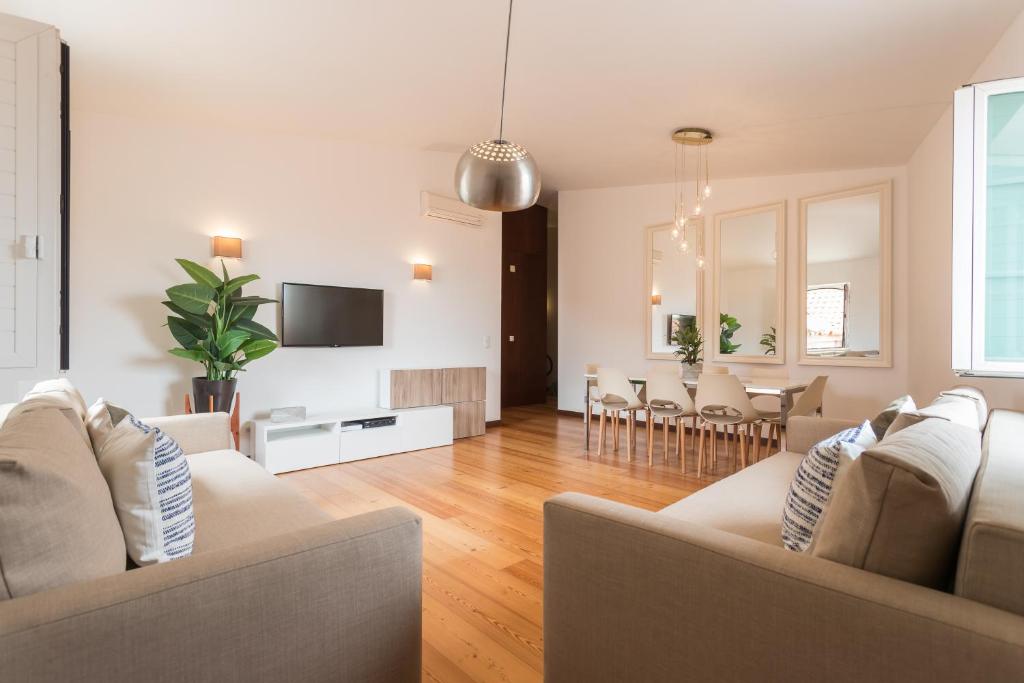 een woonkamer met een bank en een eetkamer bij Alfama Modern Two-Bedroom Apartment w/ River View and Parking - by LU Holidays in Lissabon