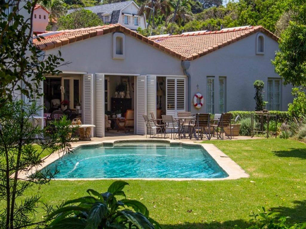 a house with a swimming pool in front of a yard at Maison H Guest House in Durban