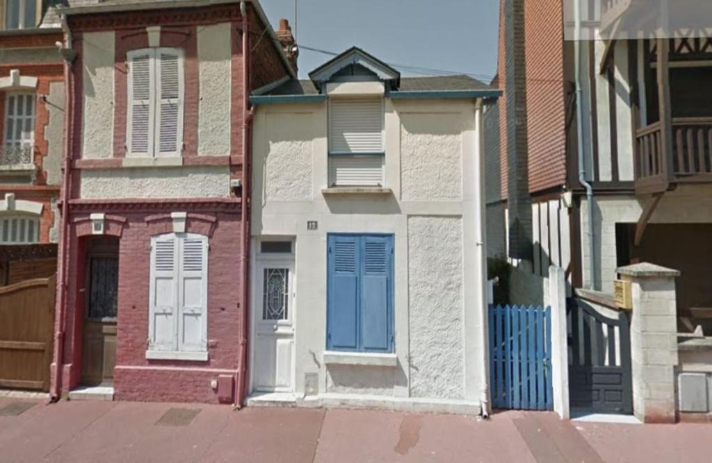 a row of houses with blue doors on a street at Maison de Pêcheurs en centre ville in Deauville