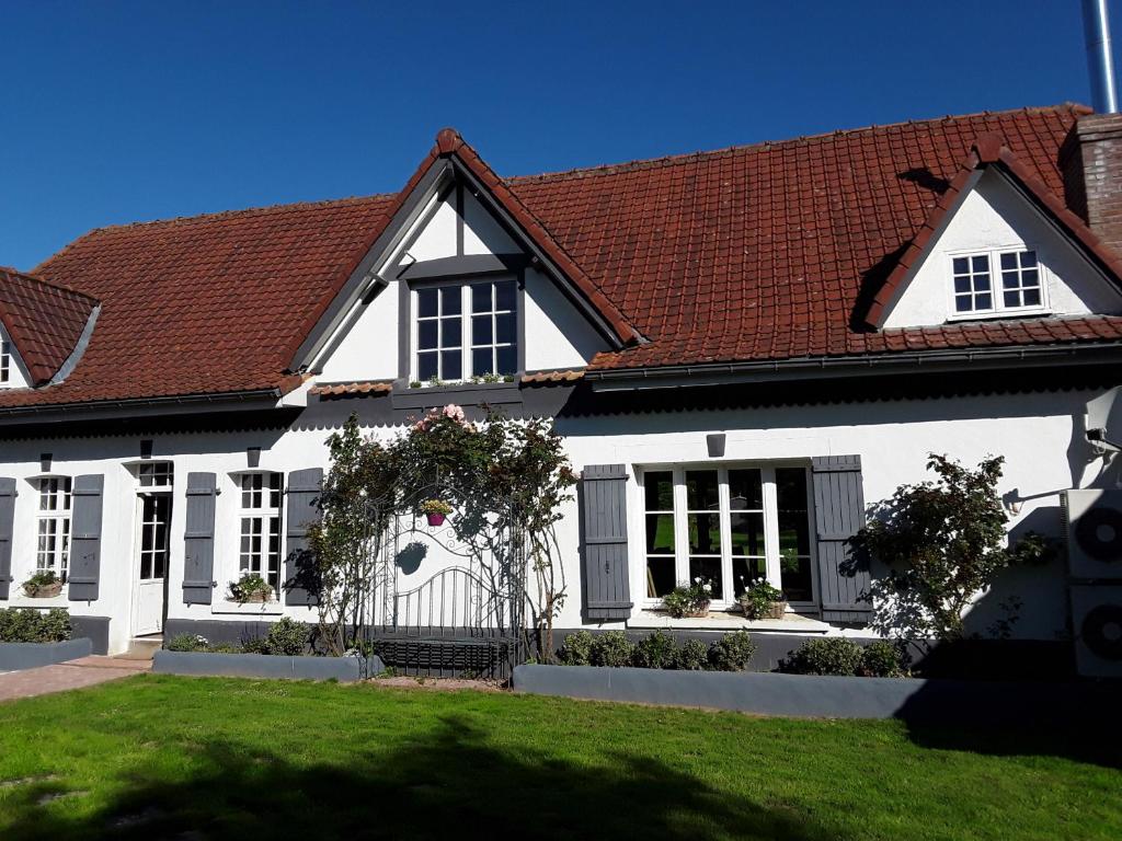 une maison blanche avec un toit rouge dans l'établissement Au Moulin de Valérie, à Frencq