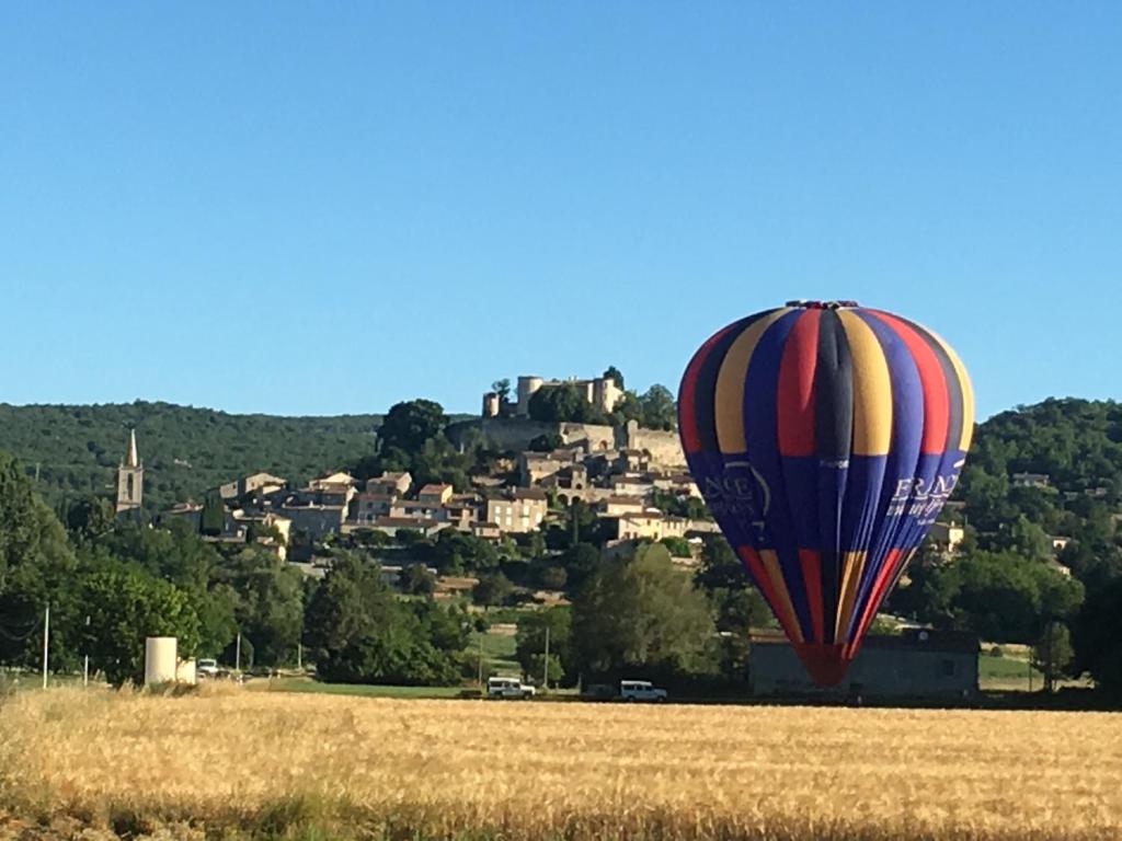 een heteluchtballon die over een veld vliegt bij Chez Calou in Mane