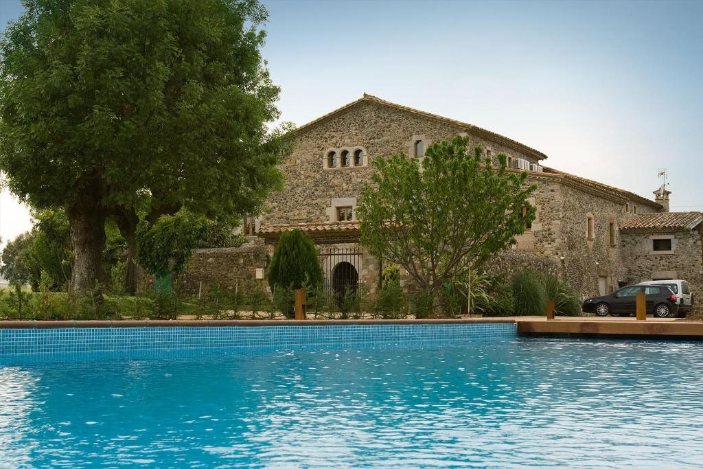 ein Haus mit einem Pool vor einem Gebäude in der Unterkunft Mas la Casassa in Sant Gregori