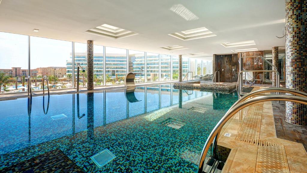 a large swimming pool in a building with glass windows at Hipotels Playa de Palma Palace&Spa in Playa de Palma