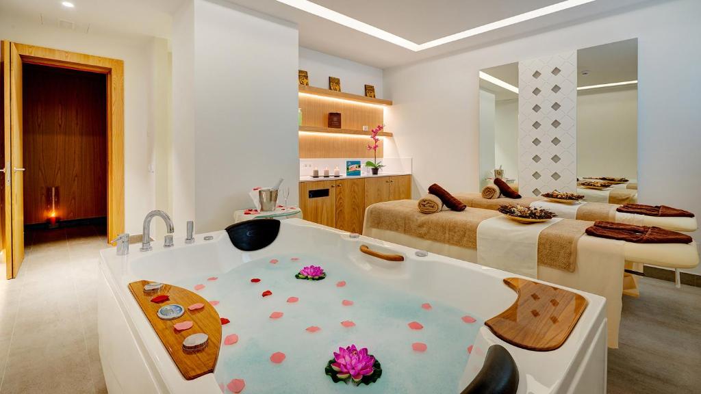 a bathroom with a tub in a room with two beds at Hipotels Playa de Palma Palace&Spa in Playa de Palma