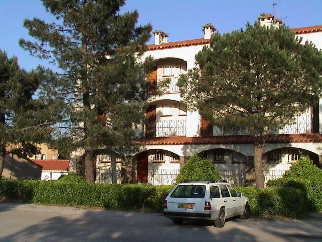 um carro branco estacionado em frente a um grande edifício em Argelès Plage-tout près de la mer em Argelès-sur-Mer