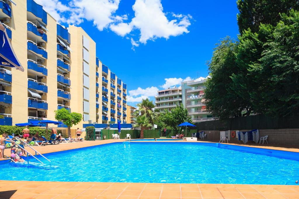 a swimming pool in front of some apartment buildings at UHC Alborán Apartments in Salou