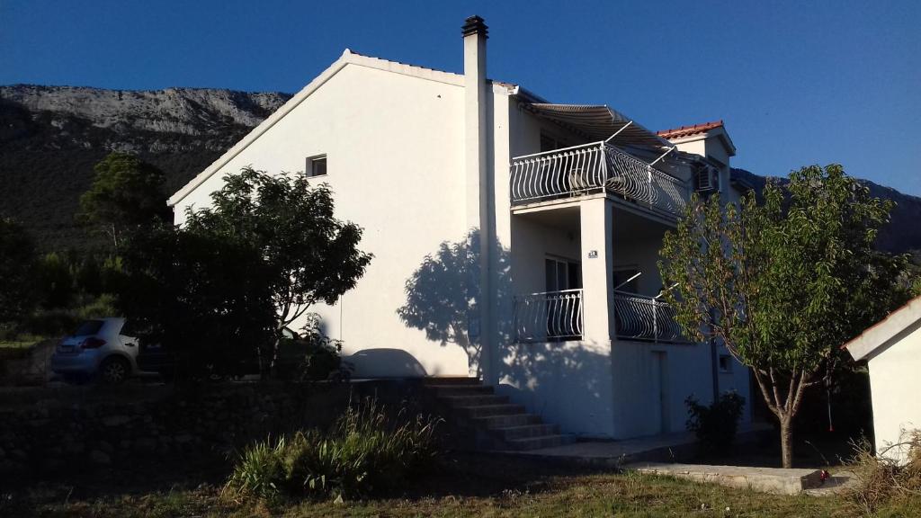 a white house with stairs and a balcony at Apartment Marin in Kaštela