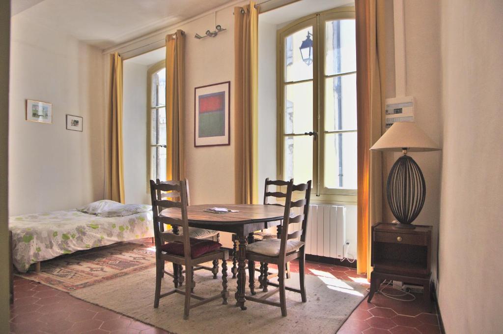 - une salle à manger avec une table, des chaises et un lit dans l'établissement La Cigale, à Saint-Hippolyte-du-Fort