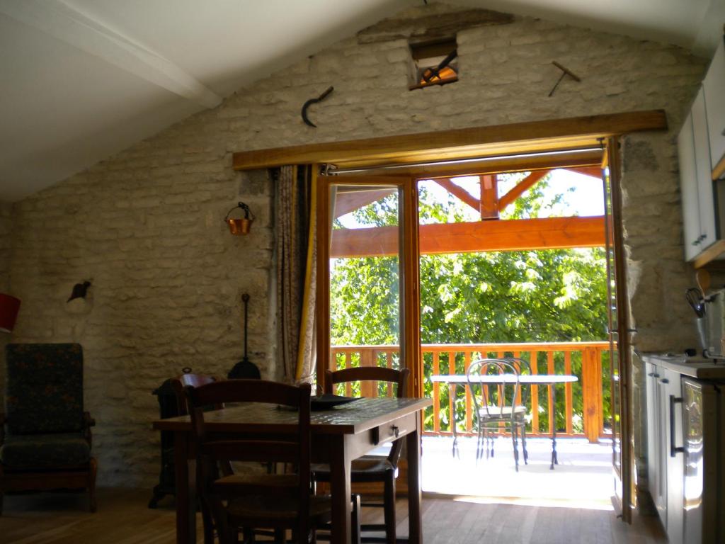 een keuken met een tafel en een glazen schuifdeur bij Au col de Cygne in Blanzac-lès-Matha