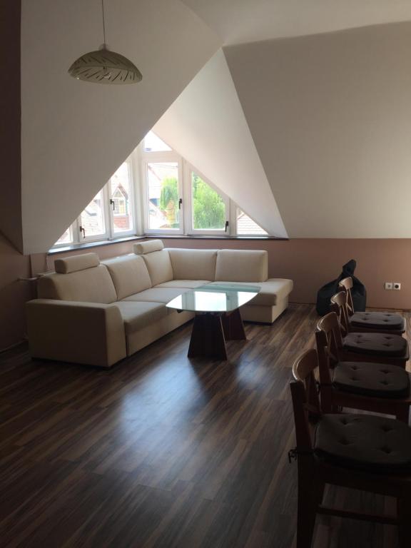 un soggiorno con divano e tavolo di Palank Apartman a Mosonmagyaróvár
