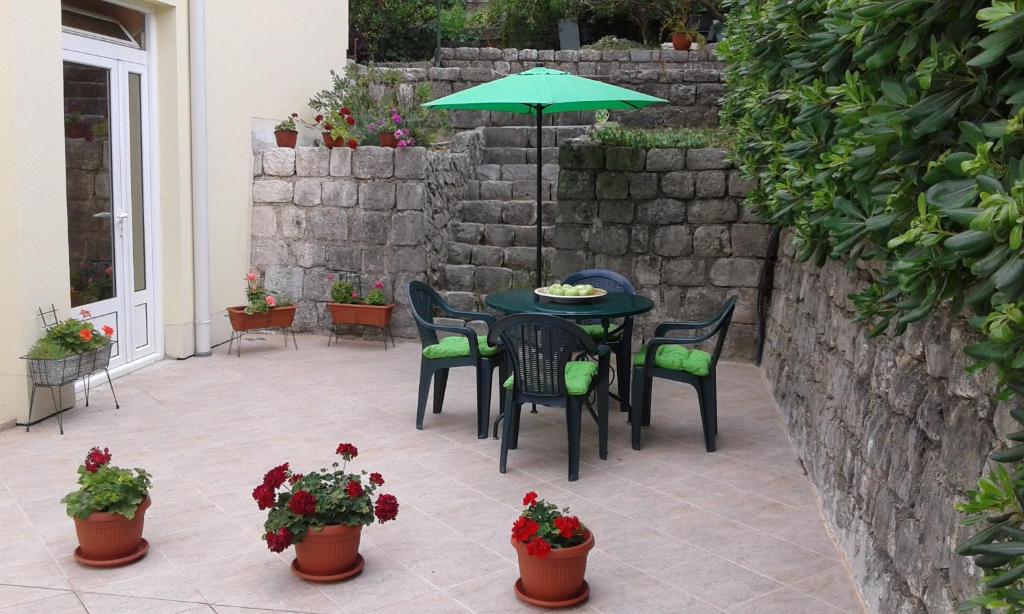 a patio with a table and chairs and an umbrella at Apartment Adela in Kotor