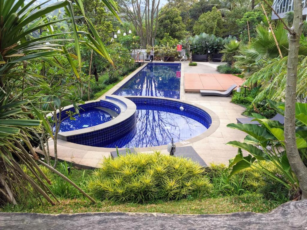 une piscine dans un jardin avec des plantes dans l'établissement TechieRoom Kotlin at Clove Garden Residence, à Bandung