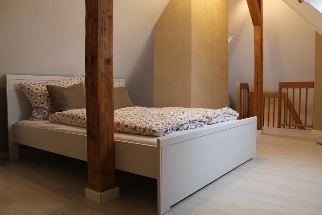 Bett in einem Zimmer mit Holzpfosten in der Unterkunft Ferienwohnung Paula in Wernigerode