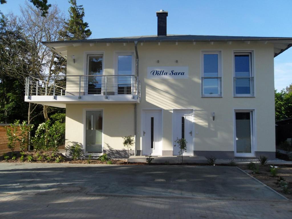 a white house with a sign that reads villa sav at Villa Sara in Göhren