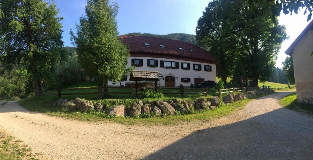 una gran casa blanca con techo rojo en un camino de tierra en Turistična Kmetija Toman, en Gornji Grad
