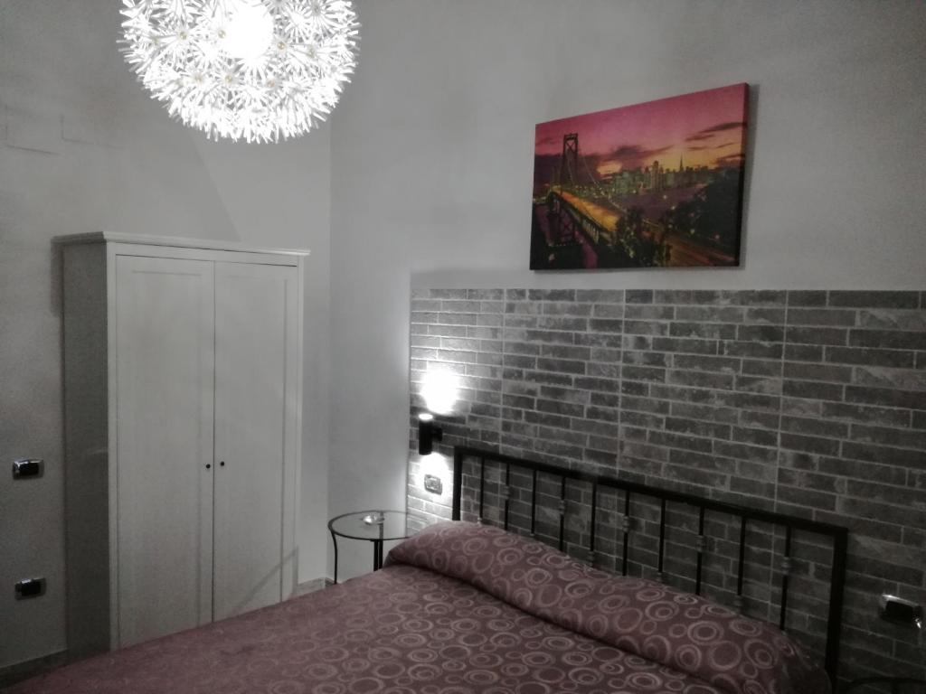 ナポリにあるHotel Primaveraのレンガの壁、ベッド付きのベッドルーム1室