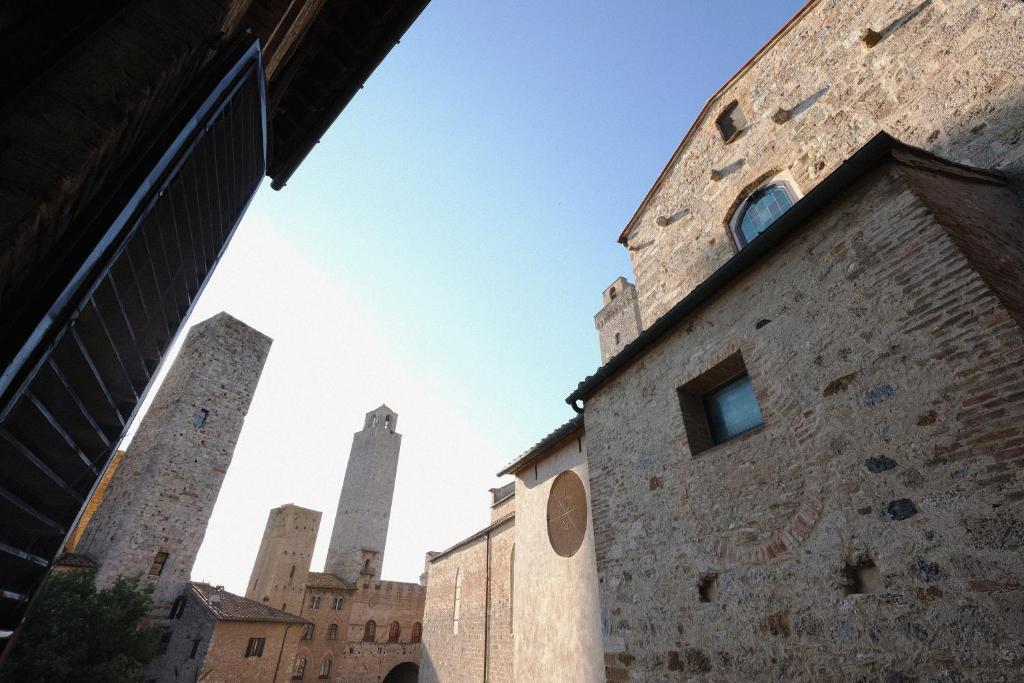 een uitzicht op twee hoge torens vanuit een gebouw bij Appartamenti Panoramici Piazza delle Erbe in San Gimignano
