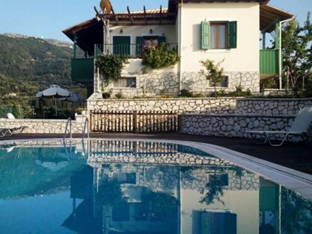 una casa y una piscina frente a una casa en Villa Milia en Áyios Nikítas