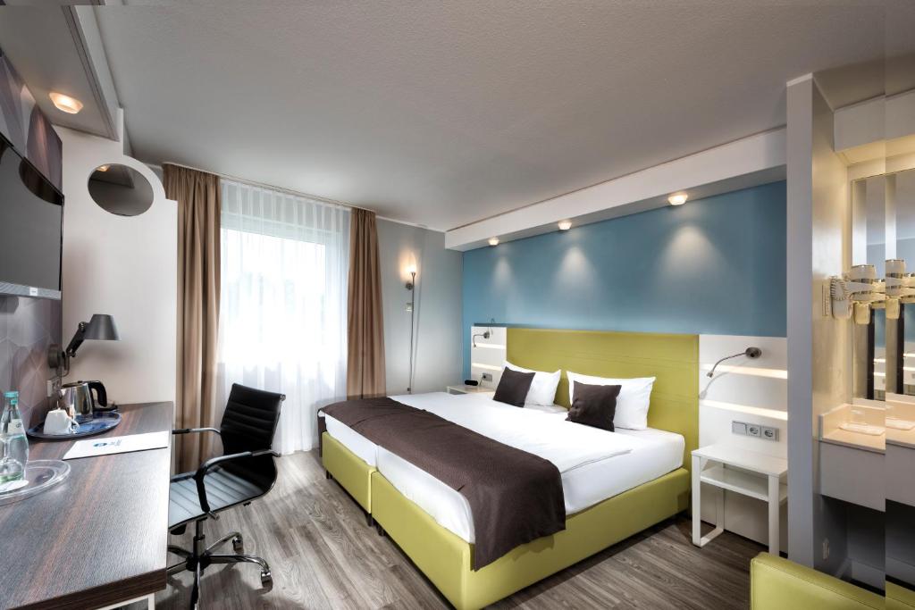 パイネにあるBest Western Hotel Peine Salzgitterのベッドとデスクが備わるホテルルームです。