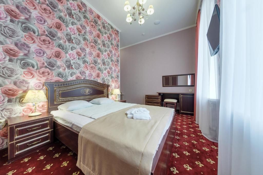 エッセントゥキにあるSanatoriy Imeni Pavlovaの花の壁のベッドルーム1室(大型ベッド1台付)