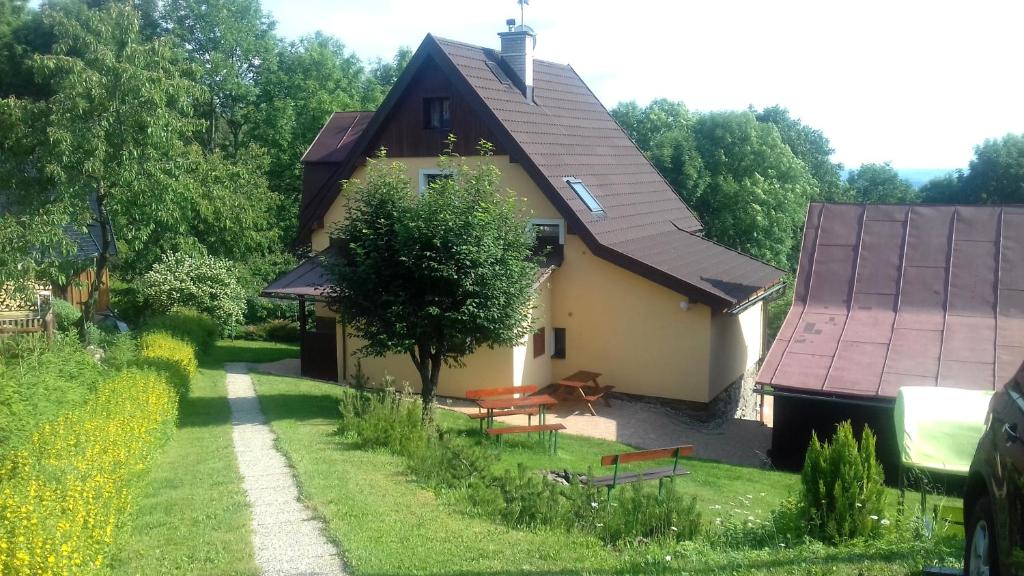 a house with two benches in front of it at Holiday Home Benecko 101 in Benecko