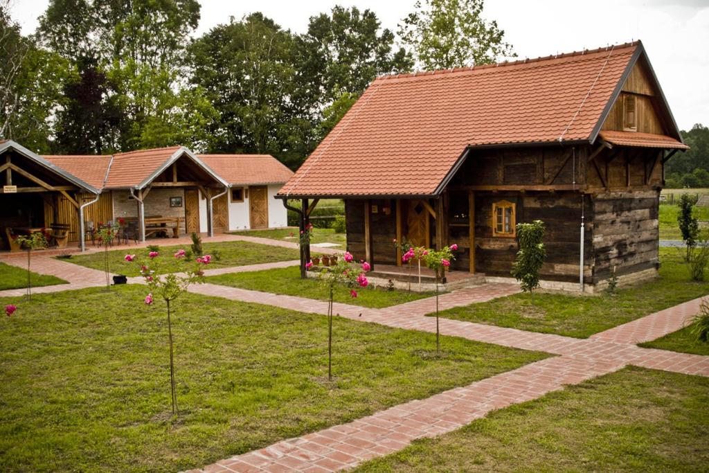 un grupo de casas con árboles delante de ellos en Ekoetno Selo Strug, en Krapje