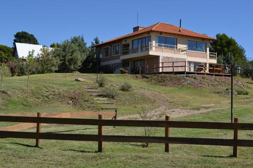 una casa en la cima de una colina con una valla en La Casa Grande, en Sierra de la Ventana