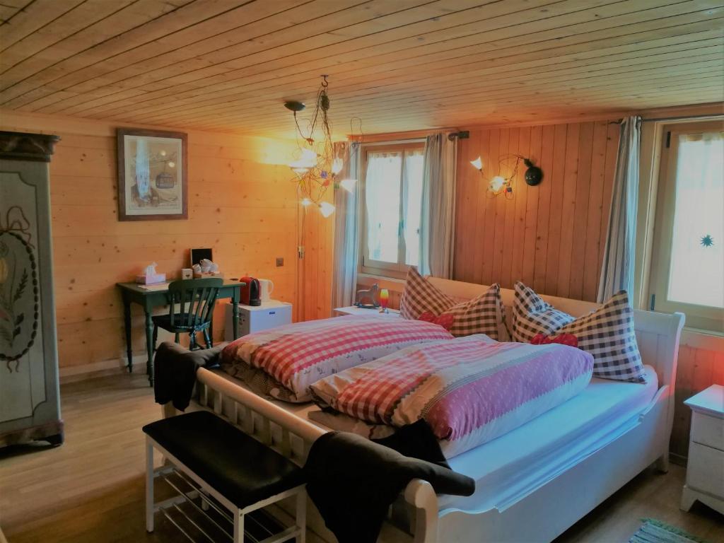 sypialnia z łóżkiem w pokoju z drewnianymi ścianami w obiekcie B&B Rosaly w mieście Chateau-d'Oex