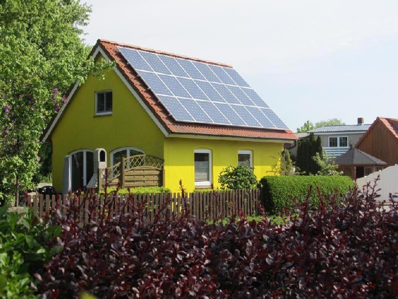 Wulfen auf FehmarnにあるFerienhaus-Maxe-Haus-Paulaの太陽光パネル付黄色の家