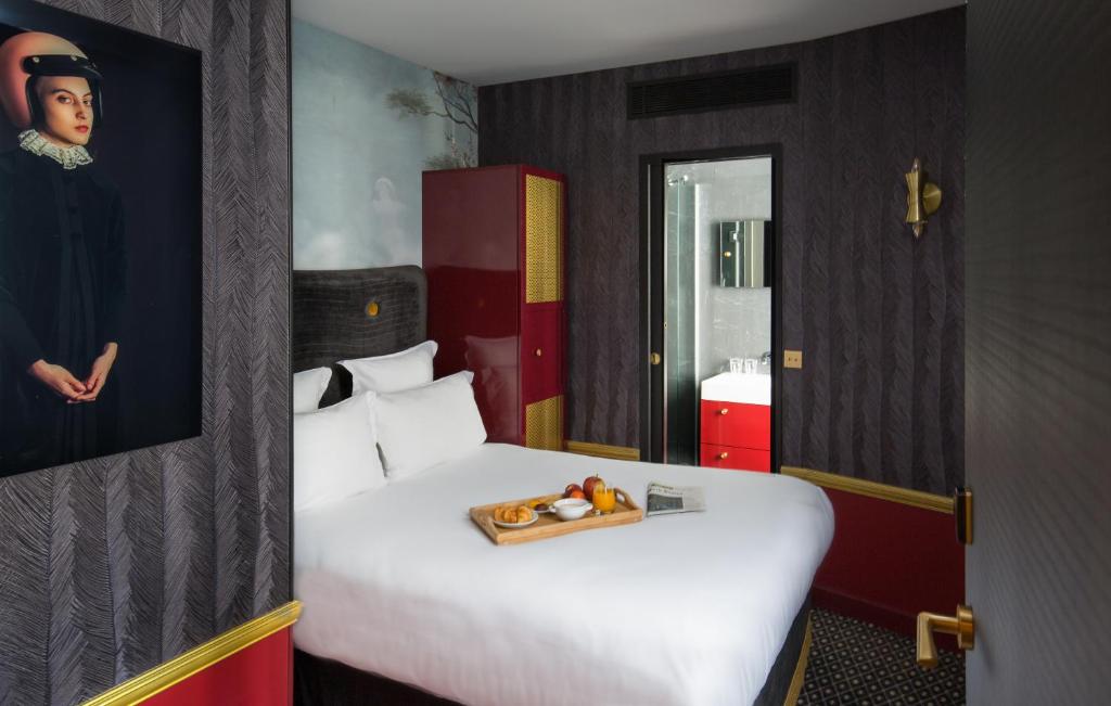 a bedroom with a bed with a tray of fruit on it at Snob Hotel in Paris