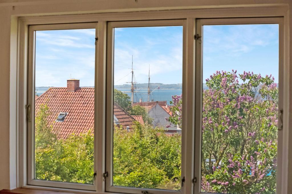 エーベルトフトにあるFerielejligheder i centrum af smukke Ebeltoftの水辺と建物の景色を望む窓