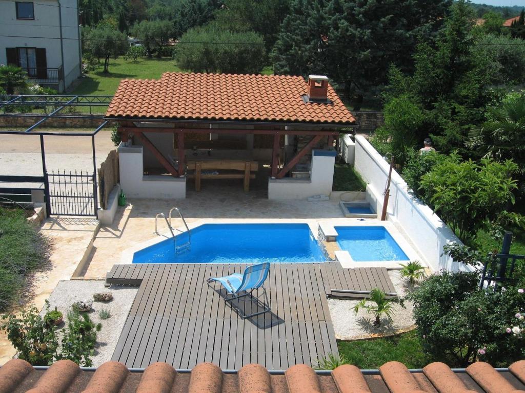 a pool with a table and a chair next to a house at Attractive holiday home in Vabriga in Vabriga