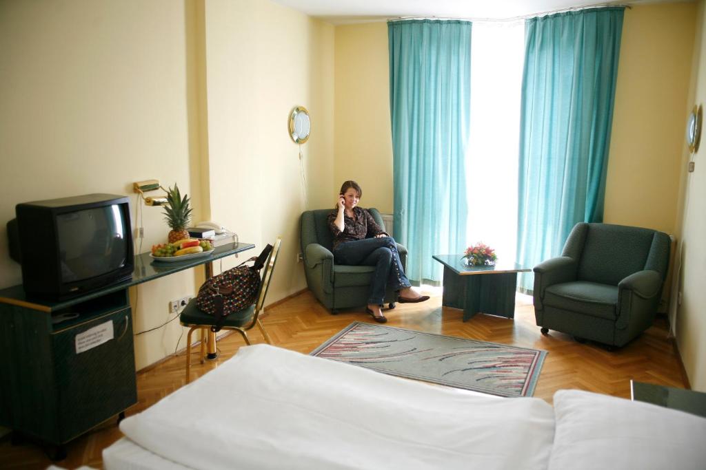 Televízia a/alebo spoločenská miestnosť v ubytovaní Hotel Bara Budapest