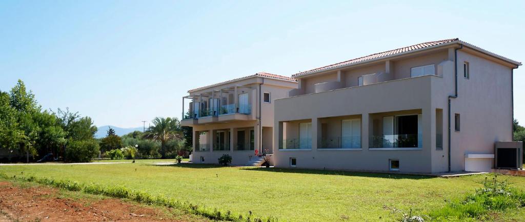 une grande maison blanche avec une grande cour dans l'établissement Sani Kasimis, à Kyparissia