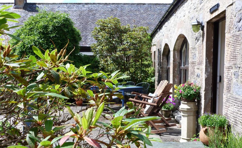 ogród z krzesłami i roślinami obok budynku w obiekcie The Steading at Barmore w mieście Tarbert