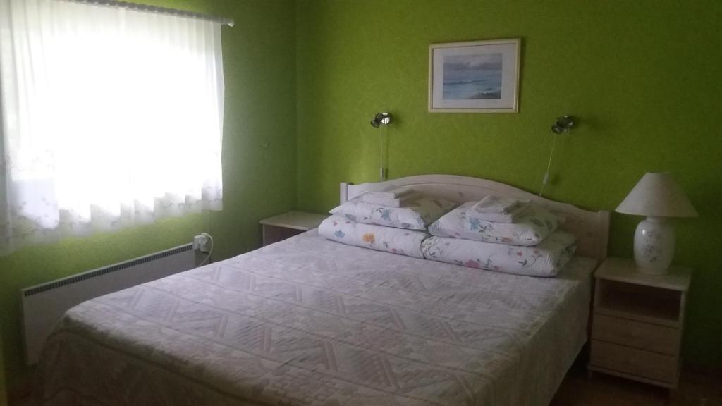 una camera da letto con un letto con pareti verdi e una finestra di Sireli Hostel a Suureranna