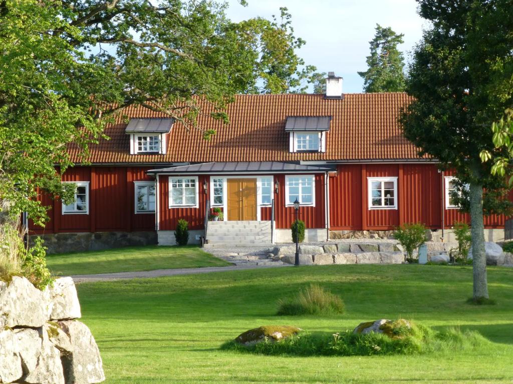 uma casa vermelha com um telhado vermelho em Katrinelund Gästgiveri & Sjökrog em Stora Mellösa