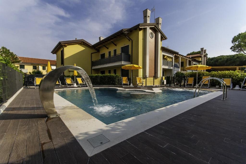 a pool with two fountains in front of a building at Appartamenti Faro Vecchio in Cavallino-Treporti