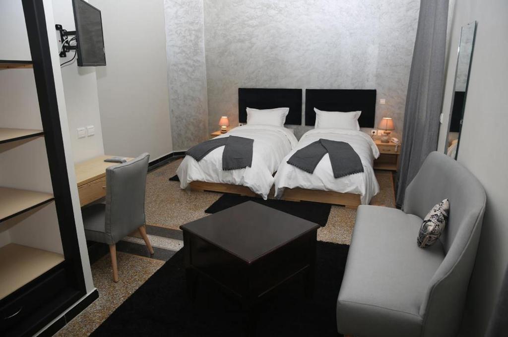 a bedroom with a bed and a desk and chairs at Point du Jour in Casablanca