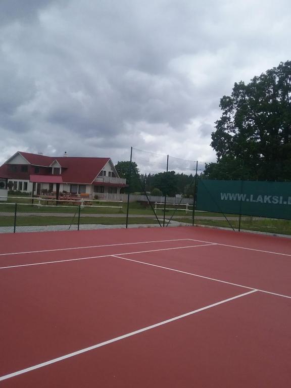 a tennis court with a building in the background at Atpūtas komplekss Lakši in Usma