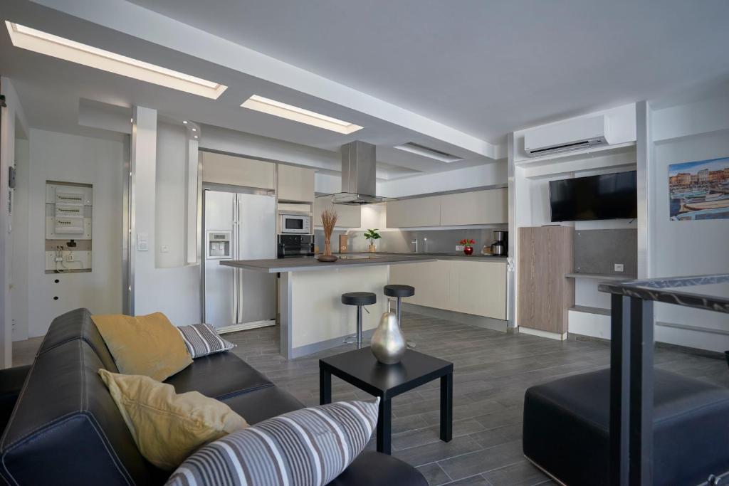 un salon avec un canapé et une cuisine dans l'établissement Capucine Duplex, à La Ciotat