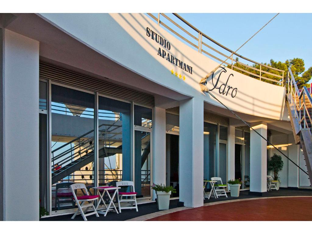 a building with chairs and tables outside of it at IDRO Studio Apartments directly at the beach in Split
