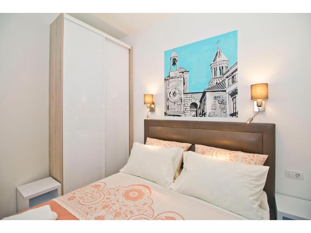 a bedroom with a bed with a picture on the wall at IDRO Studio Apartments directly at the beach in Split