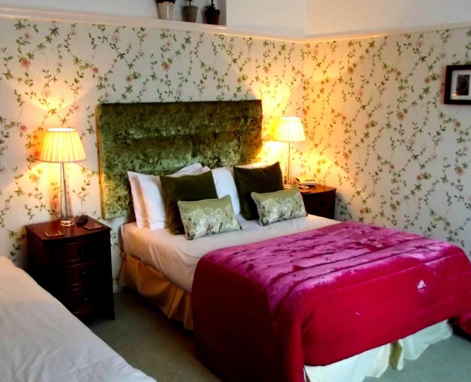 a bedroom with two beds and two lamps at Beachlands Hotel in Weston-super-Mare
