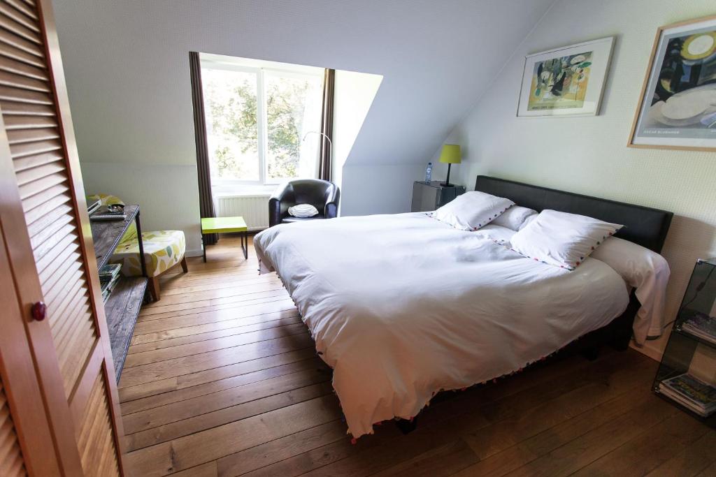B&B Le Bois Dormant في سبا: غرفة نوم بسرير كبير ونافذة