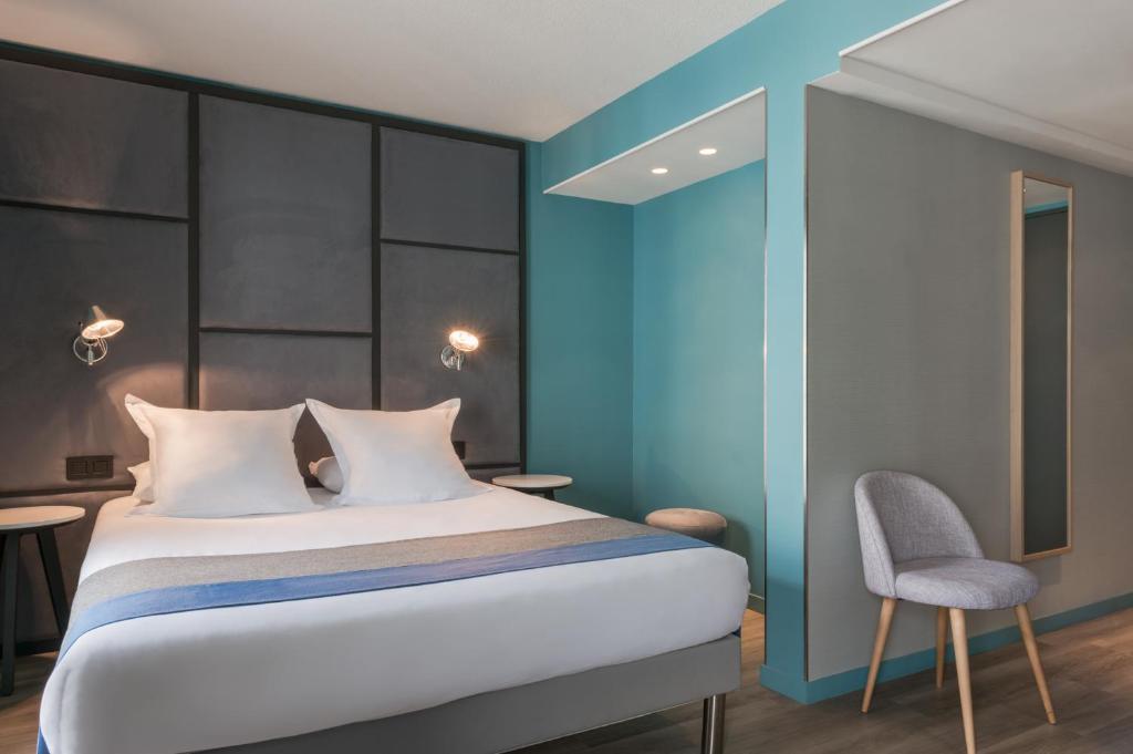 um quarto com uma cama e uma parede azul em Hôtel Sanso by HappyCulture em Paris