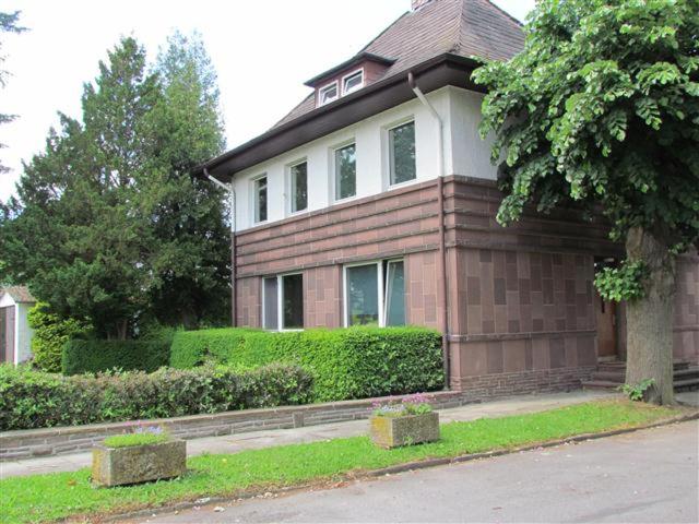 a brown and white house with bushes and trees at Ferienwohnung Oppermann in Arholzen