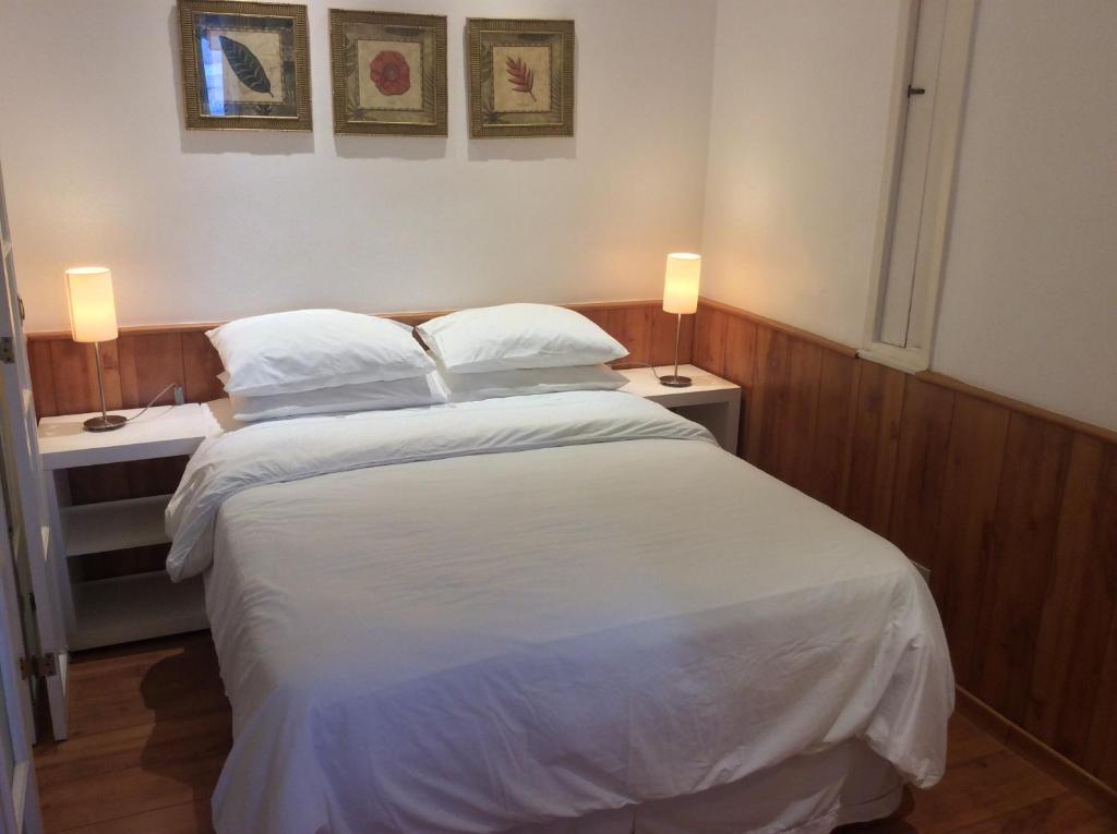 1 dormitorio con 1 cama con sábanas blancas y 2 lámparas en Ipa Prudente Pent 02, en Río de Janeiro